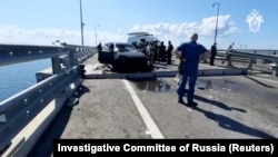 Російські слідчі та співробітники російських екстрених служб біля пошкоджених в аварії автомобілів, яка, ймовірно, виникла через руйнування після 3-ї ночі частини Кримського мосту. 17 липня 2023 року.