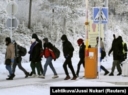Біженці з російської території йдуть через міжнародний прикордонний перехід у Салле, північна Фінляндія, 22 листопада 2023 року