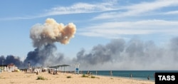Над пляжем біля селища Новофедорівка тягнеться дим з аеродрому, на території якого сталися вибухи. Крим, Сакський район, 9 серпня 2022 року
