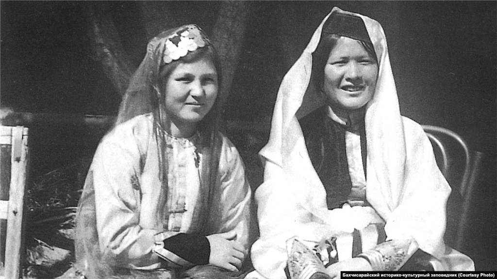 Дівчата у святковому вбранні. Бахчисарай, 1920-ті. Кримські татарки заплітали волосся в тонкі коси. На голову вдягали оксамитову шапочку, вишиту золотом або сріблом, іноді прикрашену дрібними монетами