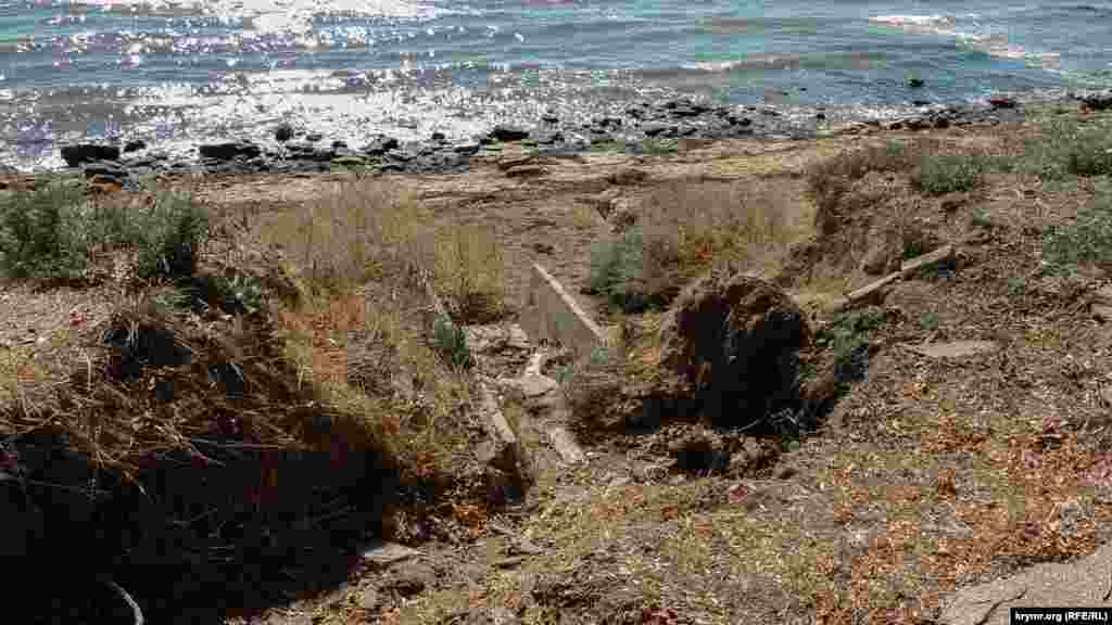 Розмита дощова каналізація і, як наслідок, зруйнований берег і асфальтована доріжка вздовж пляжу. Асфальтове покриття руйнується через розмиття ґрунту