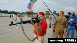Дівчинка з руху «Юнармія» прицілюється зі снайперської гвинтівки на святкуванні Дня ВДВ в Севастополі, серпень 2019 року