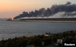 Пожежа на Керченському мосту на світанку в Керченській протоці. Україна, окупований Крим, 8 жовтня 2022 року